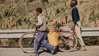 School-aged kids fetching water using bicycles