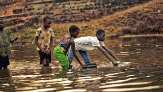 Children collecting water from an open pool